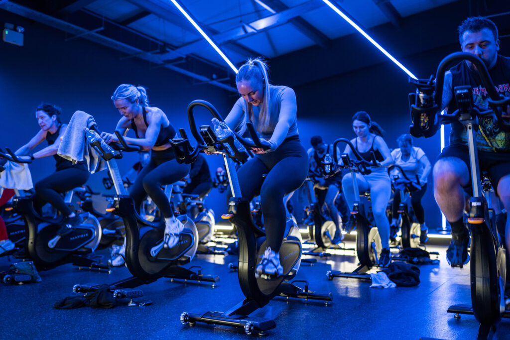 Image showing a young woman taking part in a Spin class, available with purchasing a day pass online.